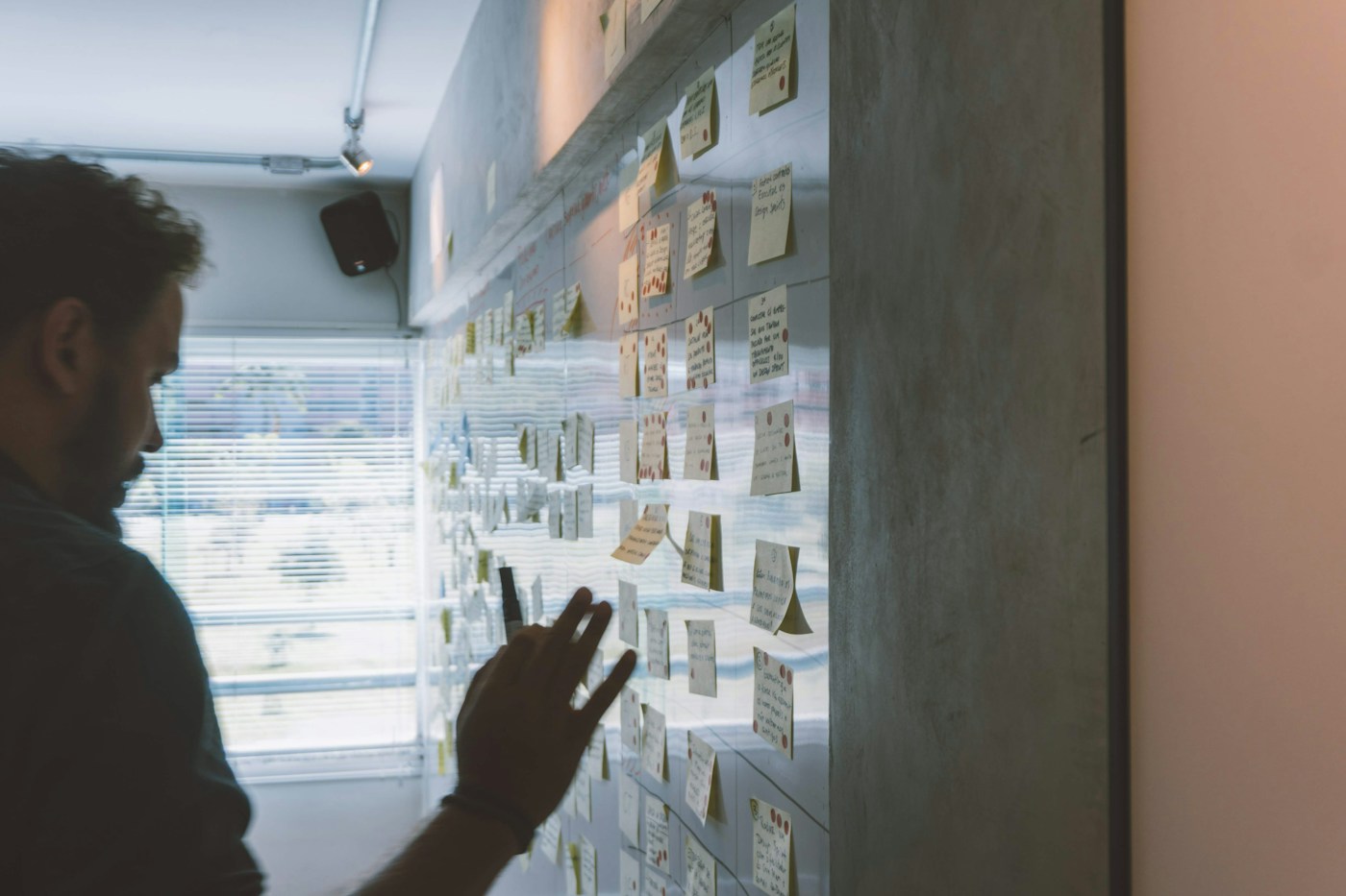 Editorial photograph of a person planning with sticky notes on a wall